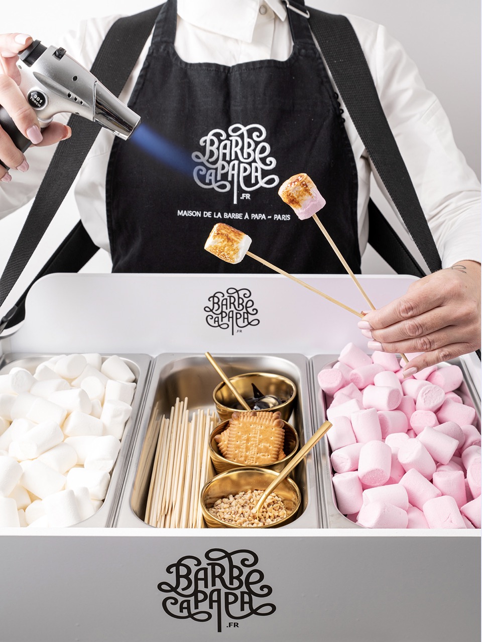 Animation marshmallow rose grillé tenue par une barbista pour événement sucré chic