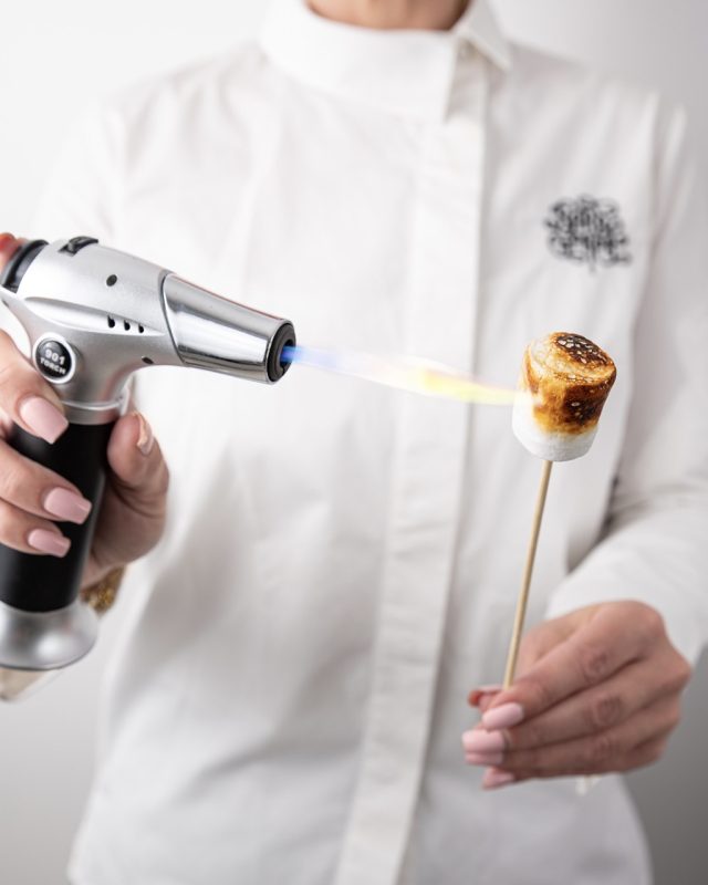 Animation live de marshmallow grillé au chalumeau par une barbista Maison de la Barbe à Papa