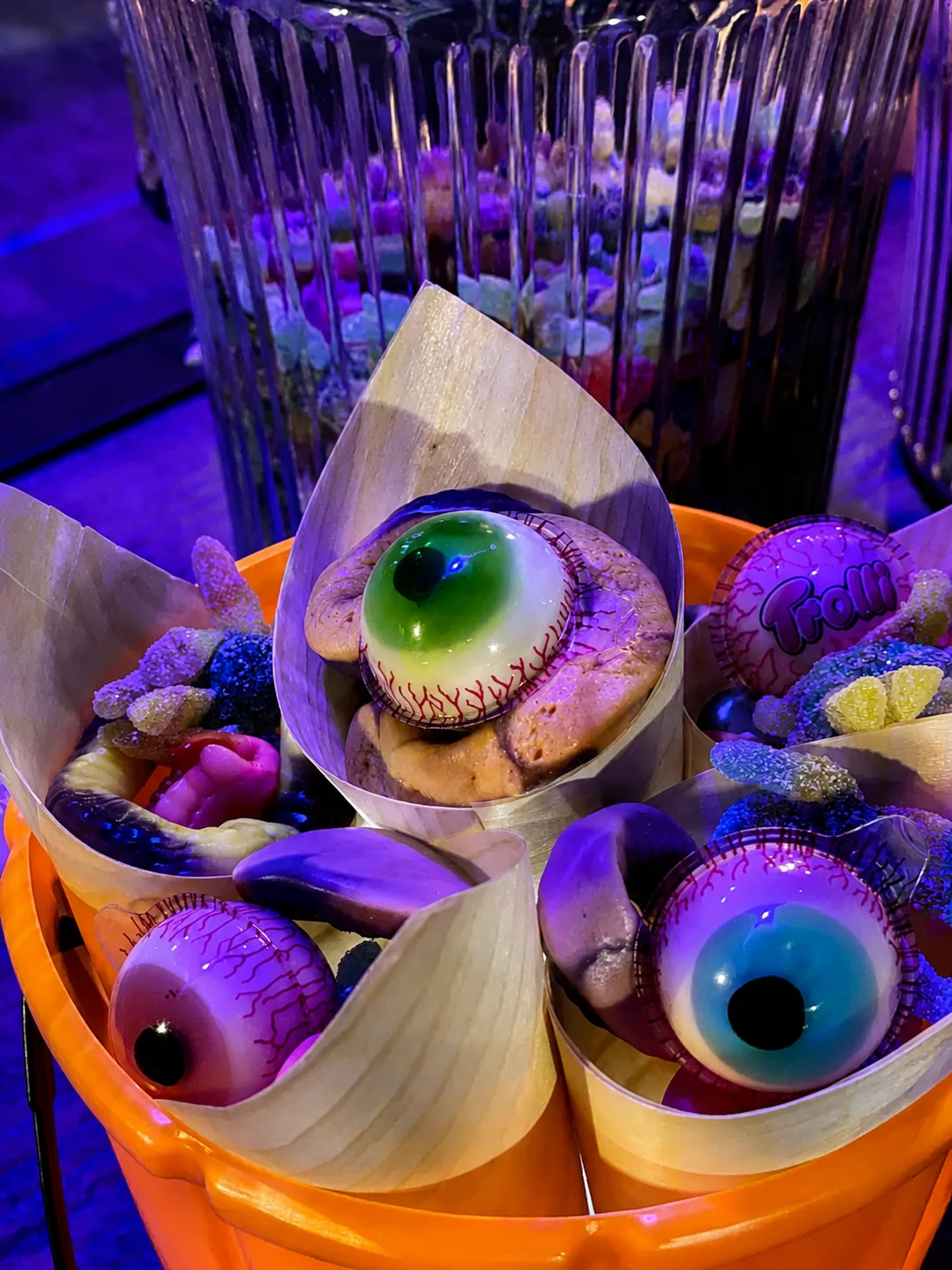 Cornets de bonbons d'Halloween et yeux décoratifs présentés dans un seau citrouille