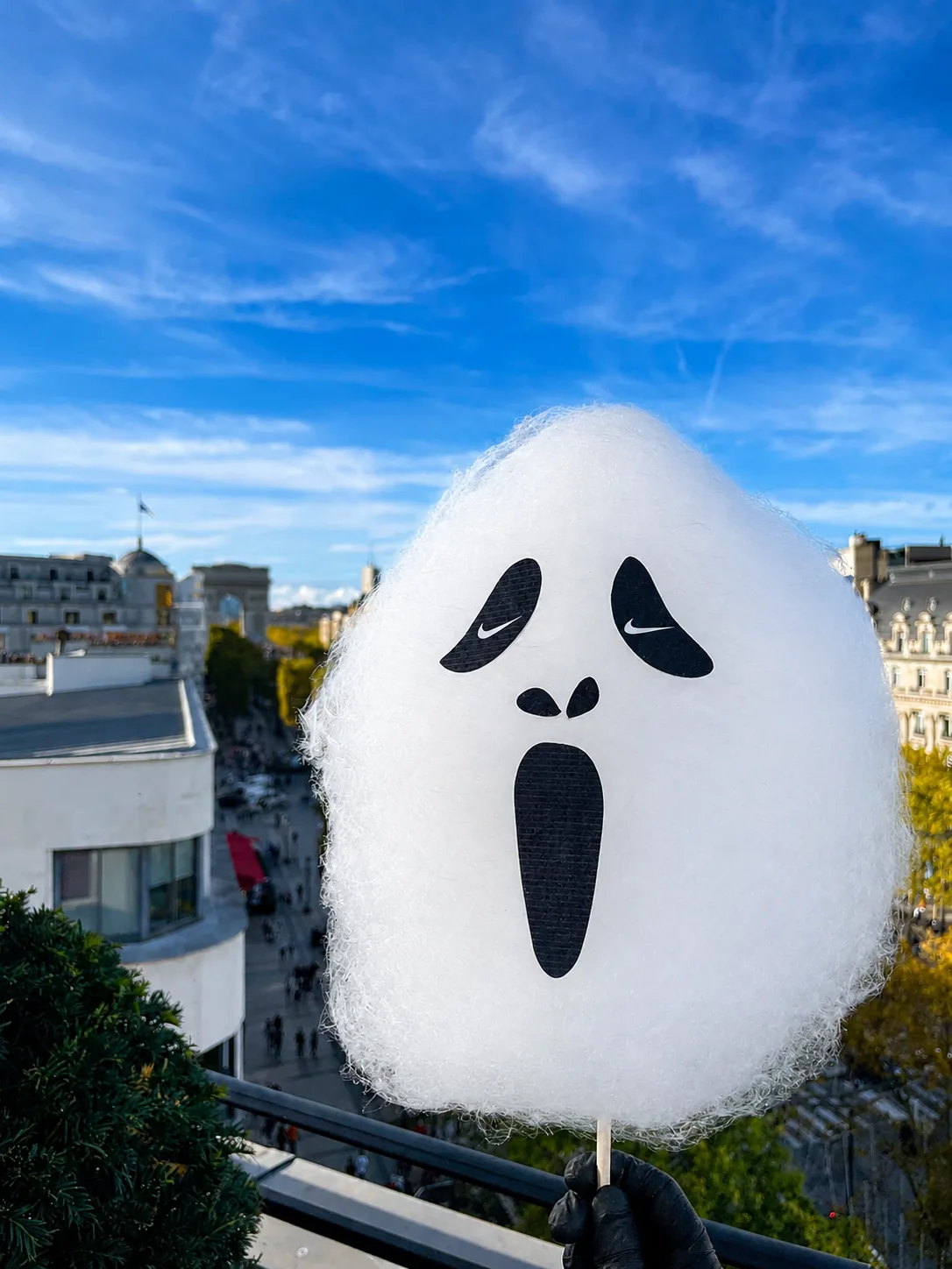 Barbe à papa fantôme au swoosh Nike devant l'Arc de Triomphe et les Champs-Élysées