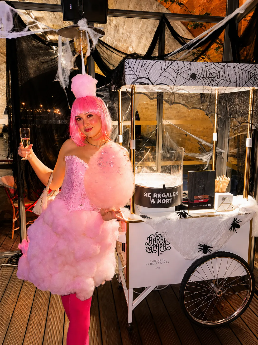 Barbista en robe de barbe à papa devant la charrette d'Halloween lors d'une soirée d'entreprise