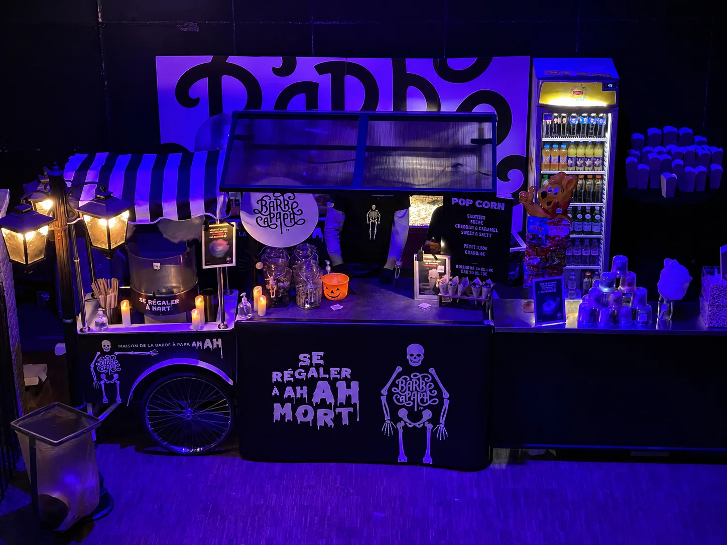 Stand barbe à papa et pop-corn d'Halloween éclairé à la lumière noire, décor squelettes