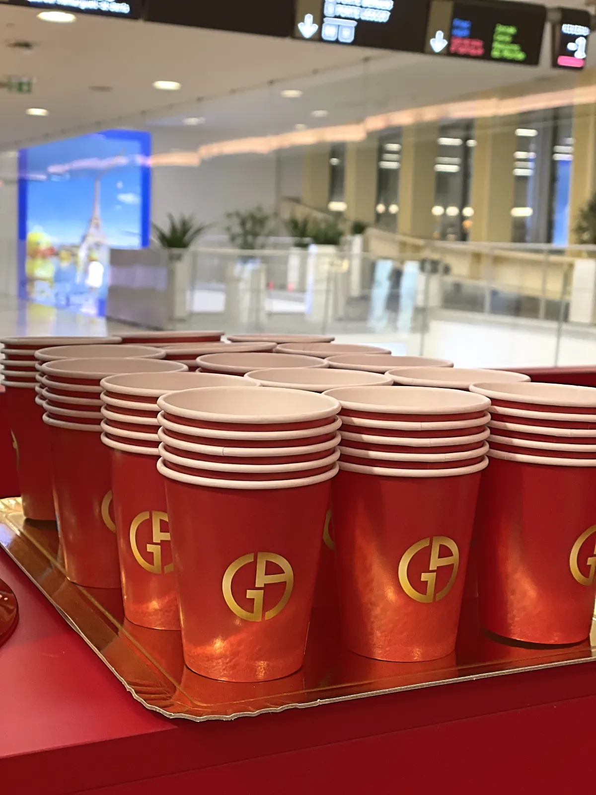Gobelets rouges personnalisés au logo doré de la marque, prêts à servir