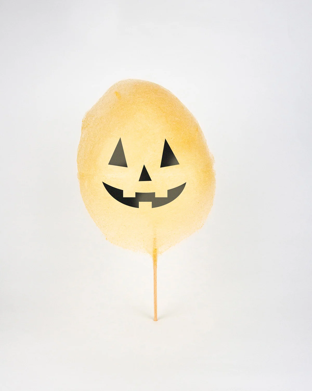 Barbe à papa d'Halloween filée en forme de citrouille, visage de Jack-o'-lantern classique