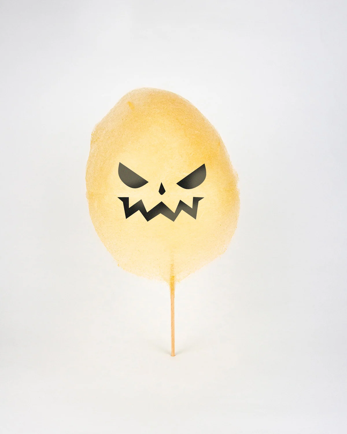 Barbe à papa d'Halloween en citrouille au visage fâché, sourcils froncés et crocs