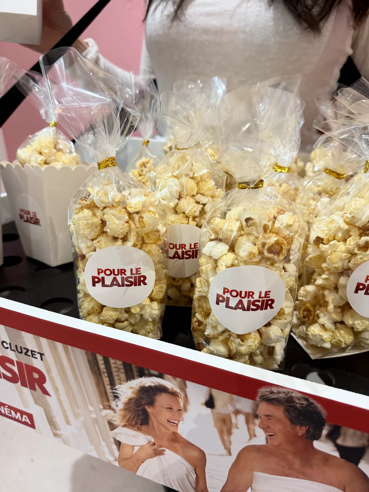 Sachets de pop-corn personnalisés devant l'affiche du film Pour le Plaisir — Maison de la Barbe à Papa