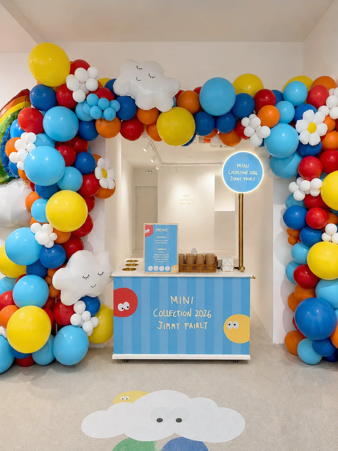 Comptoir de mini pancakes personnalisés aux couleurs de la Mini Collection 2026 Jimmy Fairly, sous une arche de ballons