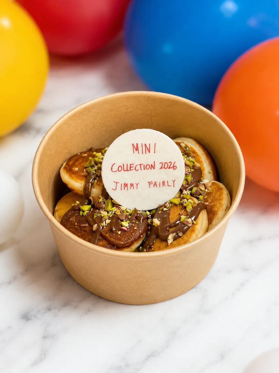Cup de mini pancakes chocolat et pistache surmontée d'un logo comestible Mini Collection 2026 Jimmy Fairly