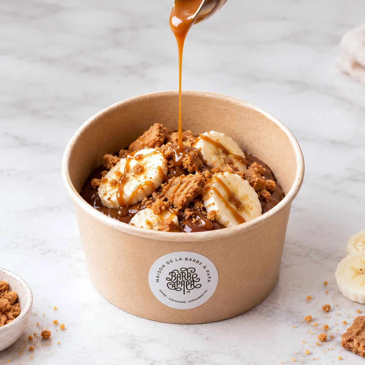 Caramel beurre salé versé sur la Raclette Choco garnie de banane et de spéculoos